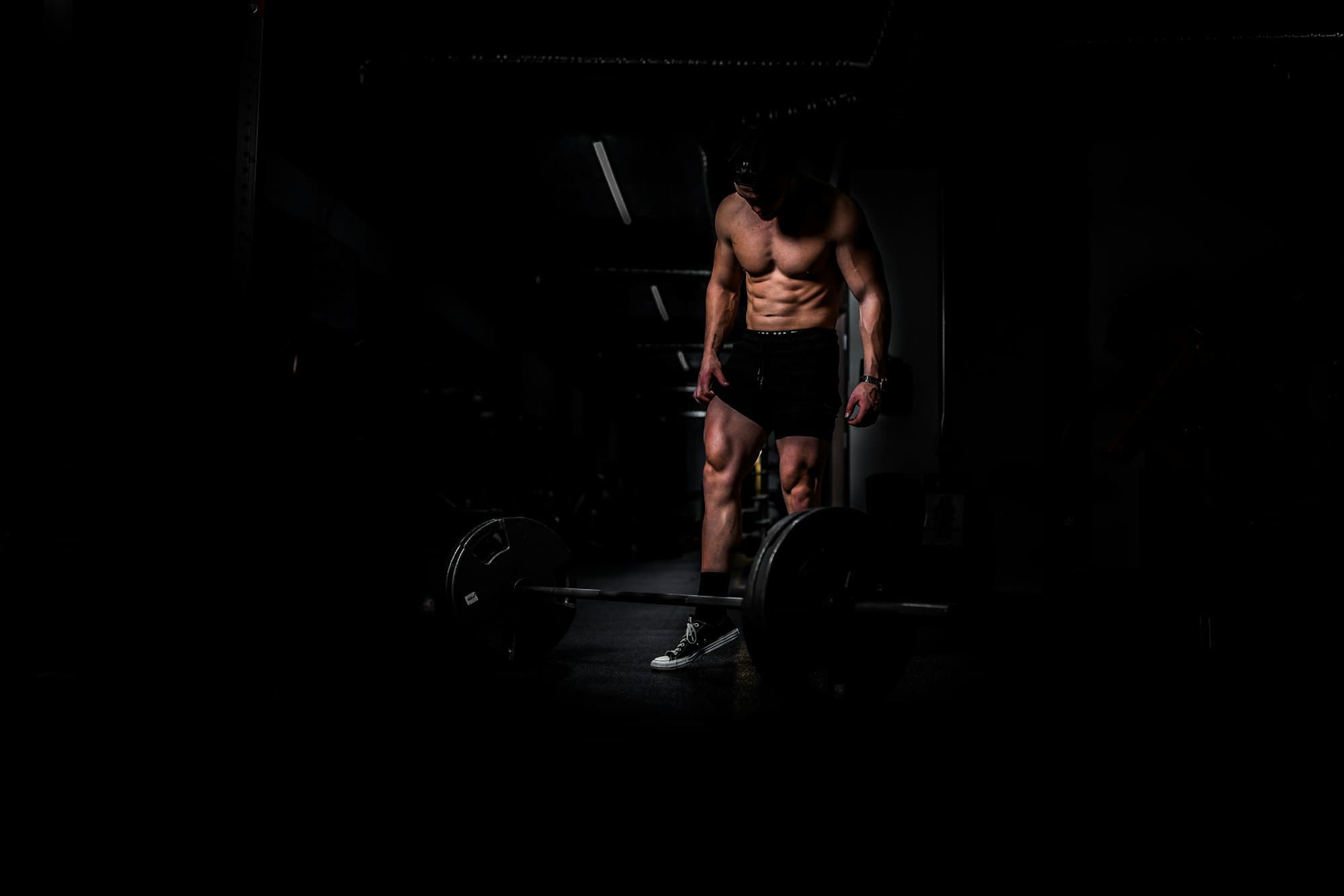 Atleta treinando em academia com iluminação baixa